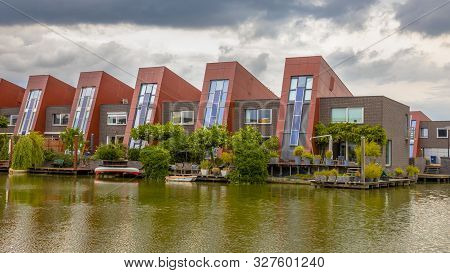 Waterfront Houses With Integrated Solar Panels And Hanging Gardens On Waterfront In Urban Area Of Th