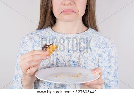 Cropped Closeup Photo Of Sad Woman Havinf Regret Of Eating Too Much Tasty Dessert Holding White Plat