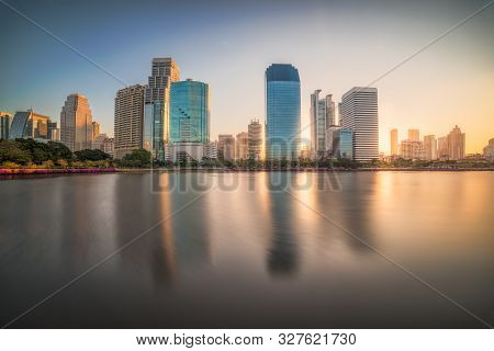Lake In Public Park Under Skyscrapers At Sunrise. Benjakiti Park In Bangkok, Thailand