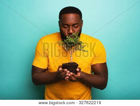 Happy Boy Kisses A Small Tree Ready To Be Planted. Concept Of Forestation
