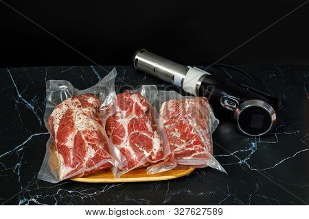 Meat And Sous Vide Cooker Immersion Circulator On A Dark Background.