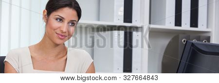 Panoramic web banner beautiful young mixed race Latina African American biracial woman or businesswoman sitting at a desk in an office with a computer panorama