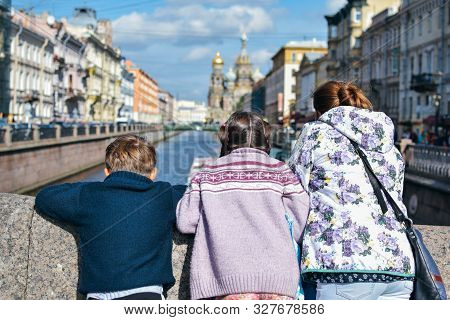Tourist Family With Mother, Doughter And Son Walk And See The Sights In Famous Place In Saint Peterb