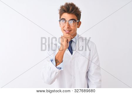 Young handsome sciencist man wearing glasses and coat over isolated white background with hand on chin thinking about question, pensive expression. Smiling and thoughtful face. Doubt concept.