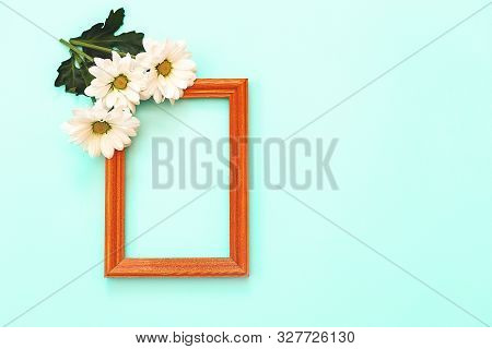 White Chrysanthemum With Wooden Frame And Copy Space On A Mint Background