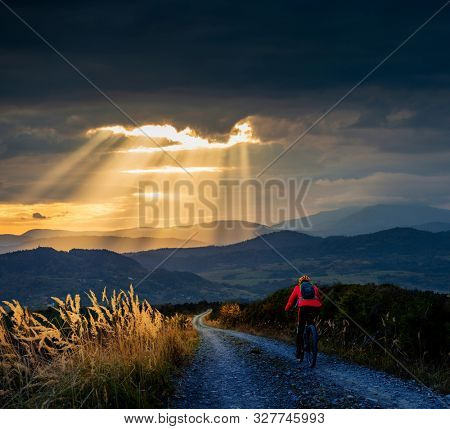 Mountain biking woman riding on bike in autumn mountains forest landscape. Woman cycling MTB flow trail track. Outdoor sport activity.