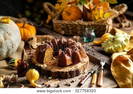 Tasty Homemade Baked Pumpkin Bundt Cake With Chocolate On Top Stands On Wooden Board On Rustic Table