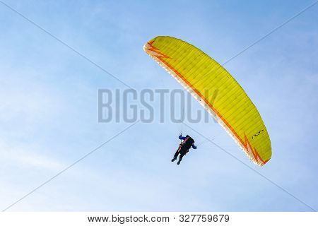 Togliatti, Russia - 10 March 2019. Paragliding On The Background Of Blue Sky. The Yellow Paraglider 