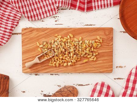 Pine nuts on wooden board and white vintage background