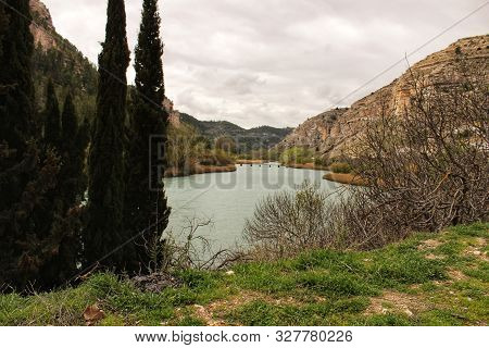 Tolosa Reservoir Surrounded By Vegetation And Mountains In Alcala Del Jucar Village, Albacete, Spain