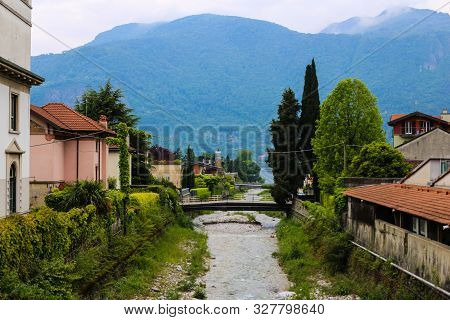 Picturesque Italian Town Mandello With Lovely Houses, Trees And Alps In Background.
