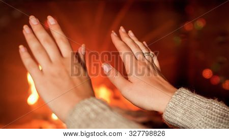 Closeup Image Of Female Hands Warming At Burning Firepalce