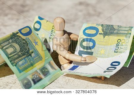 Wooden Dummy Puppet Holding Hundredth Euro Banknotes. Money Or Business Concept. Abstract Conceptual