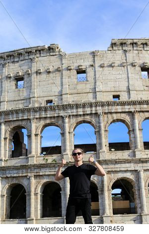 Man Standing Near Coloseum In Background In Rome, Italy.