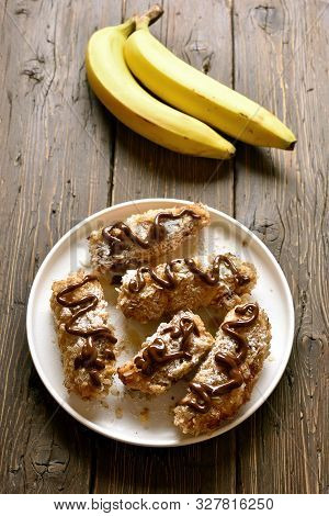 Tasty Fried Bananas On Plate Over Wooden Background. Dessert From Pan Fried Bananas In Asian Style.