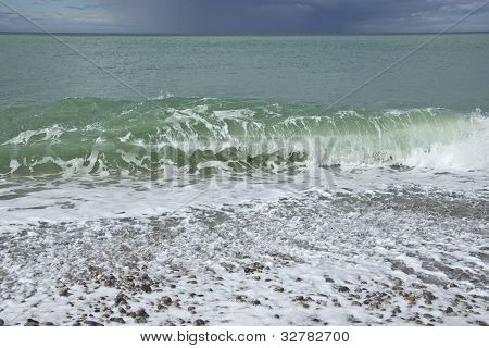 Wave, Sunny Beach And Storm Clouds