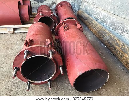 Red Gland Expansion Joints For Heating Main On Concrete Floor. Heat And Power Concept.