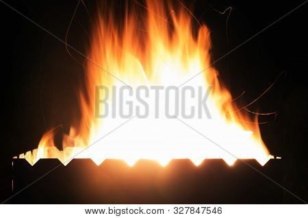Big Fire And Silhouette Of Brazier On Black Background. Flame Of Fire In Dark. Bonfire In Barbecue A
