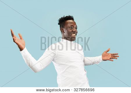 Nice To See You. Young African-american Man Isolated On Blue Studio Background, Facial Expression. B