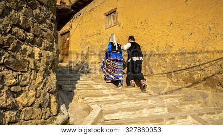 Unidentified Iranian Couple In Traditional Persian Clothes Climbing Stairs In Masuleh Village, Gilan