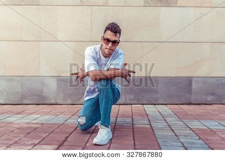 Dancer Pose Sits Break Dance, Hip-hop. Summer City, Background Wall. Active Youth Lifestyle, Young M