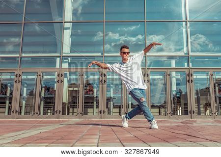 Dancer In Motion Dancing Break Dance, Hip Hop. In Summer City, Background Glass Windows Clouds. Acti