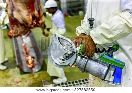 Butcher Cutting Meat With A Meat Saw