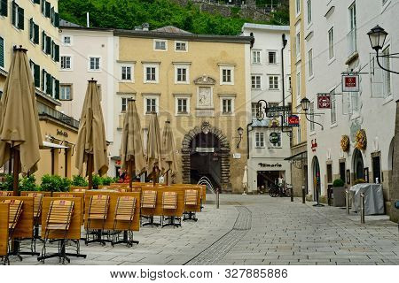Salzburg, Austria - May 26, 2019: Tables And Chairs Of An Outdoor Cafe Sit Folded Up In The Early Mo