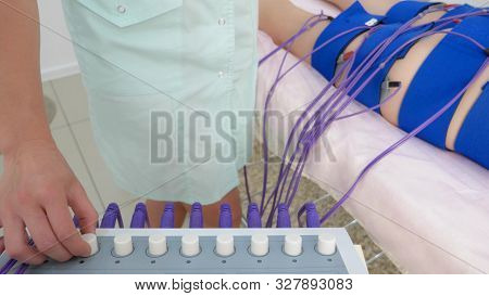 The Girl Lies On The Couch And Receives The Procedure Of Myostimulation On Her Legs And Buttocks In 