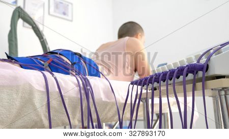 The Girl Lies On The Couch And Receives The Procedure Of Myostimulation On Her Legs And Buttocks In 