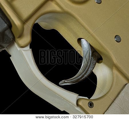 Trigger That Is On A Copper Colored Ar-15 With A Black Background