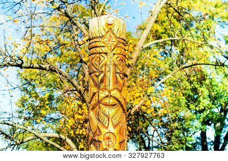 Wooden Idol Or Pagan God Against The Backdrop Of An Autumn Landscape. Close-up, Copy Space