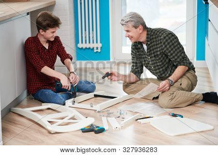 father and son work together. kitchen chair assembling
