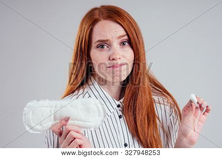 Closeup Photo Of Young Redhead Businesswoman In Striped Shirt Holding Hygiene Pad Choosing Tampon St