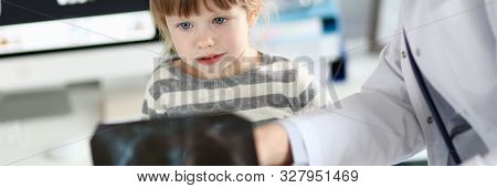 Portrait Of Concentrated Child Looking At Radiogram Shot Of Lungs. Professional Doctor Showing Black