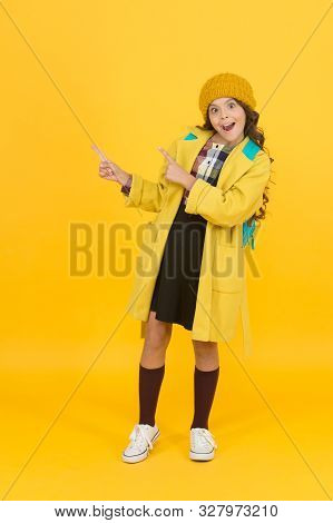 Look At Closely. Surprised Child In Autumn Fashion Pointing At Something. Small Schoolgirl With Open