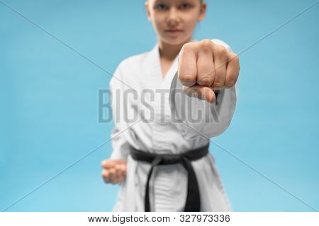 Close Up Of First, Position Of Karate. Confident Junior Practicing Punching. Young Girl In White Kim