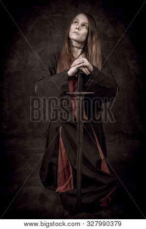 Full Length Portrait Of Young Long Haired Woman Wearing A Medieval Costume. Sitting Pose Leaning On 