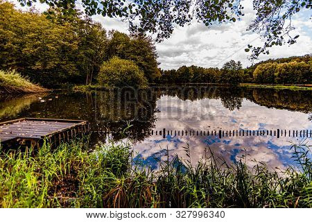 Lake With An Impressive Mirror Reflection, Which Reflects The Vegetation And Trees That Are Around, 