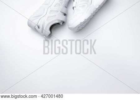 Top View Two White Kid Sneakers On The Side With Velcro Fasteners For Quick Shoeing With Copy Space 