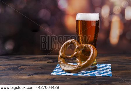 Glass Of Beer And Traditional Oktoberfest Food - Salted Pretzels On Wooden Background. Copy Space