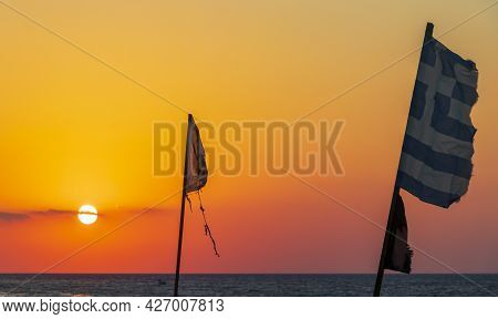 Flags At The Most Beautiful Sunset Ialysos Beach Rhodes Greece.