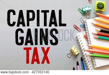 Closeup On Businessman Holding A Card With Text Capital Gains Tax, Business Concept Image With Soft 