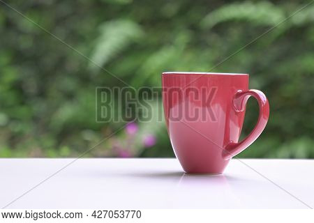 Hot Coffee In Red Cup On Table With Nature Bokeh Background. Copy Space.
