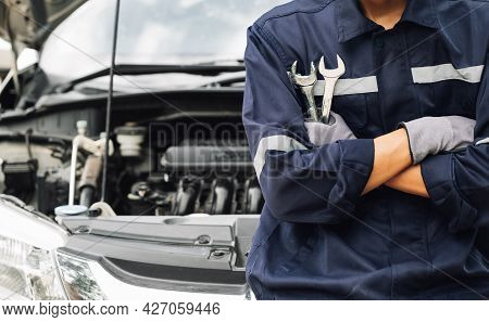 Hand Of Car Mechanic With Wrench. Auto Repair Garage. Mechanic Works On The Engine Of The Car In The