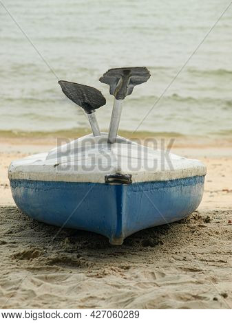 A Single Canoe On A Beach With A Pair Of Oars. Selective Focus Points. Blurred Background