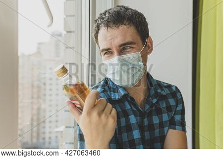 Alcoholism, Alcohol Addiction And People Concept - Male Alcoholic With Bottle Of Rum At Home. An Une