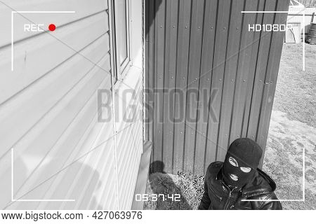 A Man In A Black Mask Is Trying To Rob A House. Simulation Of Recording From A Surveillance Video Ca