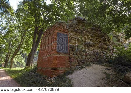 Gdov, Russia - July 19, 2020: Ruins Of A Defensive Wall With A Memorial Plaque On A Sunny July Day. 