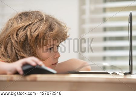 Portrait Of Concentrated Kid Surfing The Internet In School. Young Happy Schoolboy Using Computer. C